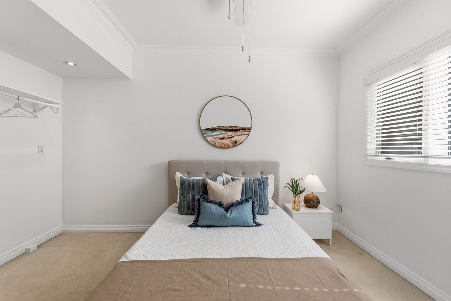 Calm bedroom with tufted headboard and circular wall art